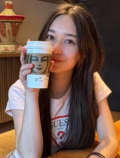 マクダウル凛奈さんがスターバックスコーヒーを手に取っている写真