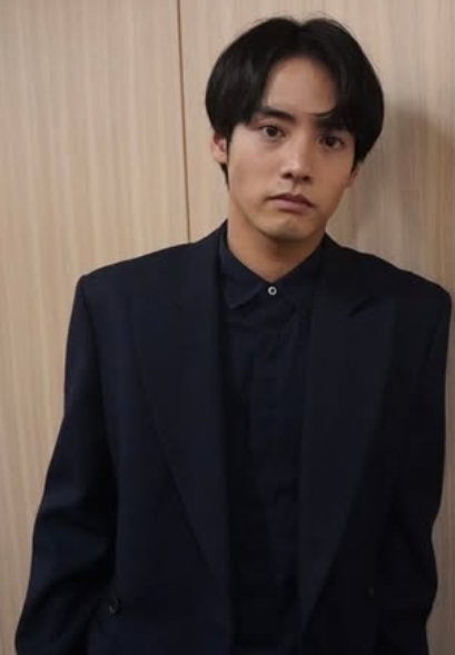 楽屋前の壁にもたれて撮影している赤楚衛二