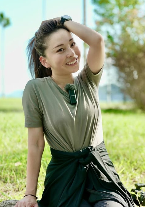 Tシャツ姿で髪をかき上げている仲れいこ