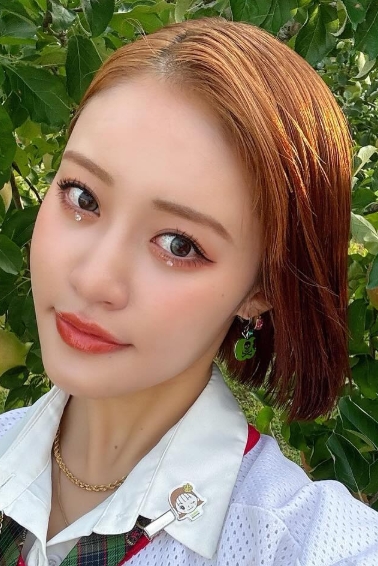 リンゴの木の前で写真を撮る王林