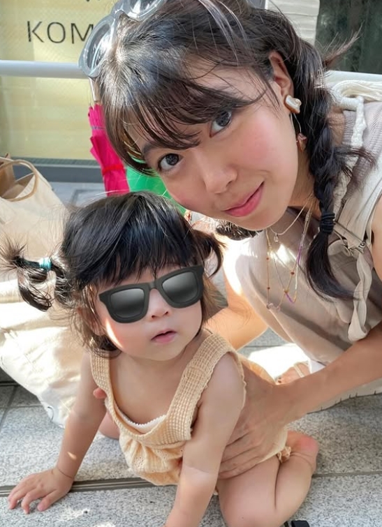 娘さんがハイハイをしている格好に寄り添う石橋穂乃香の２ショット写真