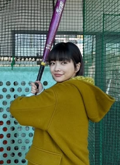 バッティングセンターの打席に立ってバットを構えている見上愛