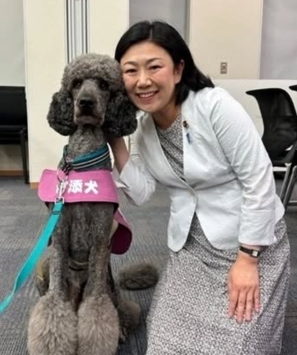付添犬のプードルと一緒に撮影している牧島かれん