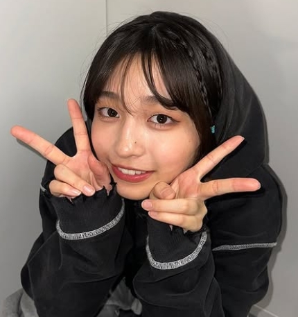 黒のパーカー姿でしゃがんでダブルピースをしている沢田京海