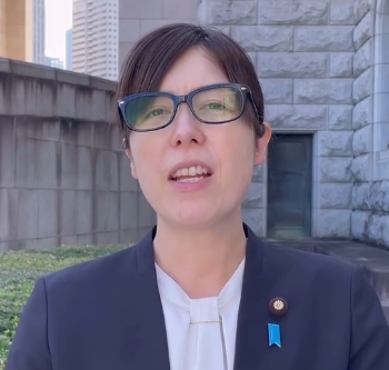 黒縁眼鏡でスーツ姿の小野田紀美