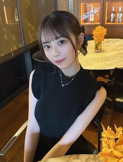 黒のノースリーブのニット姿でカフェでお茶をしている菊地姫奈