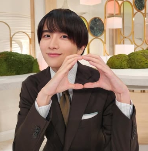 ブラウンスーツを着た板垣李光人が室内スタジオで手でZeroを作りながら笑顔を見せている様子