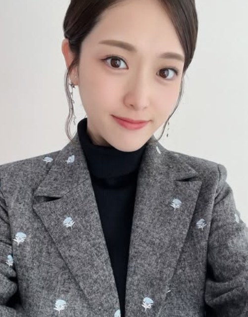 グレーの花柄ジャケットと黒のタートルネックを着た松村沙友理さんの自撮り写真