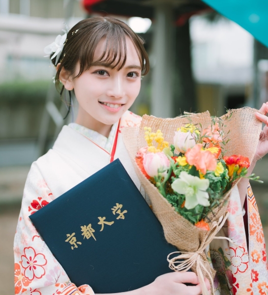 京都大学の卒業式で袴姿に身を包み、卒業証書と花束を手に笑顔を見せる今井優里さん